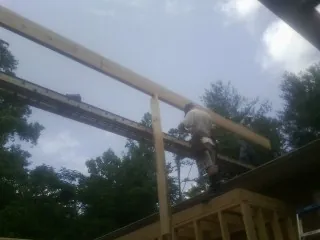 Carpenter setting a ridge beam over a new addition frame — Ice Dam Removal by Roofing Brothers in East Marion