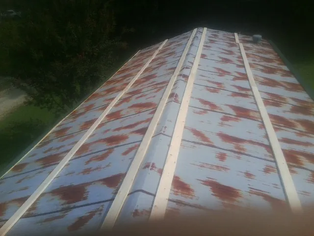 Rusted metal roof panels with new wood purlins before replacement — Storm Damage Roof Repair in East Marion by Roofing Brothers