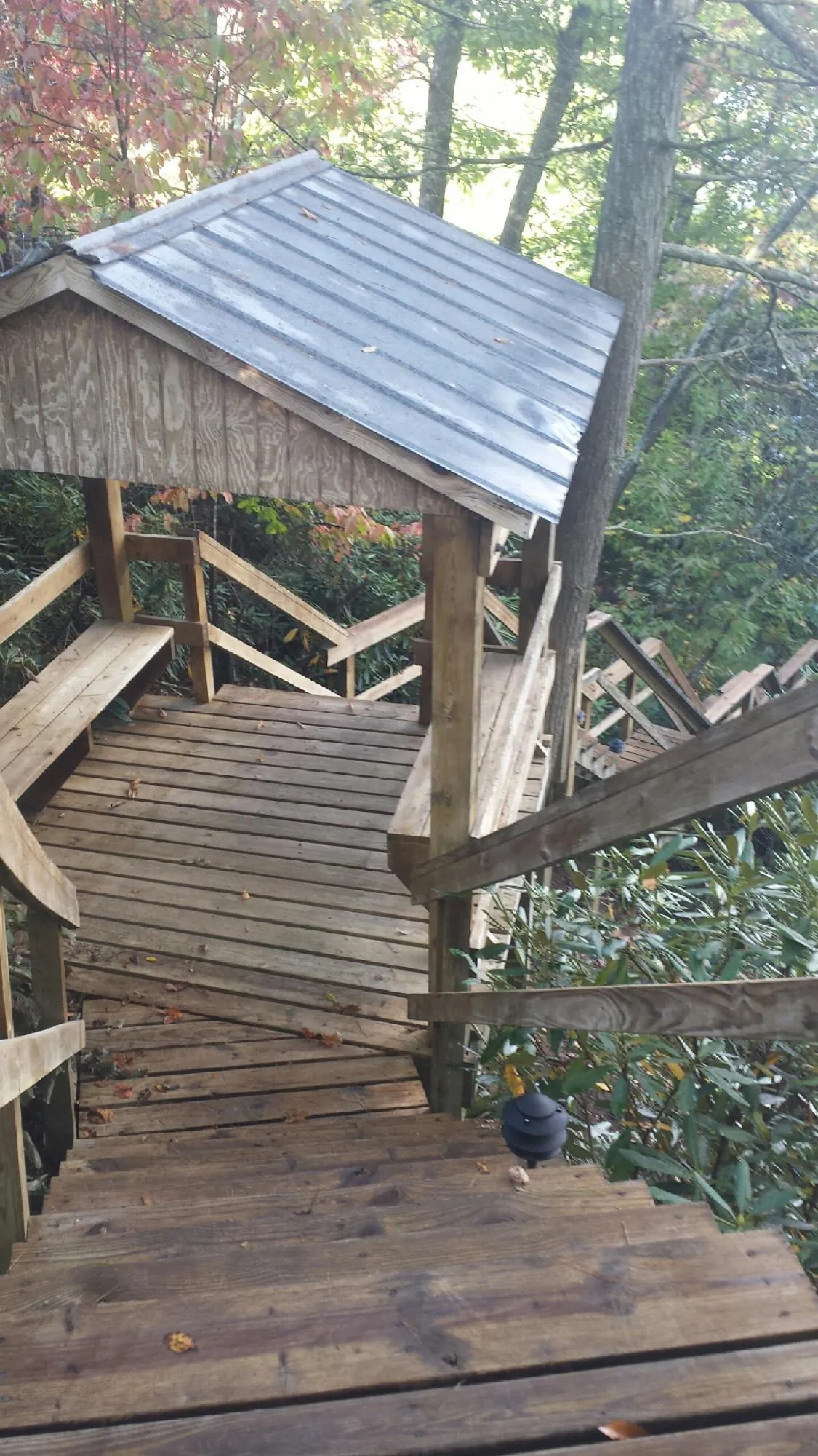 Metal roofed shelter over wooden steps on a wooded walkway — Skylight Repair & Installation work by our crew in East Marion
