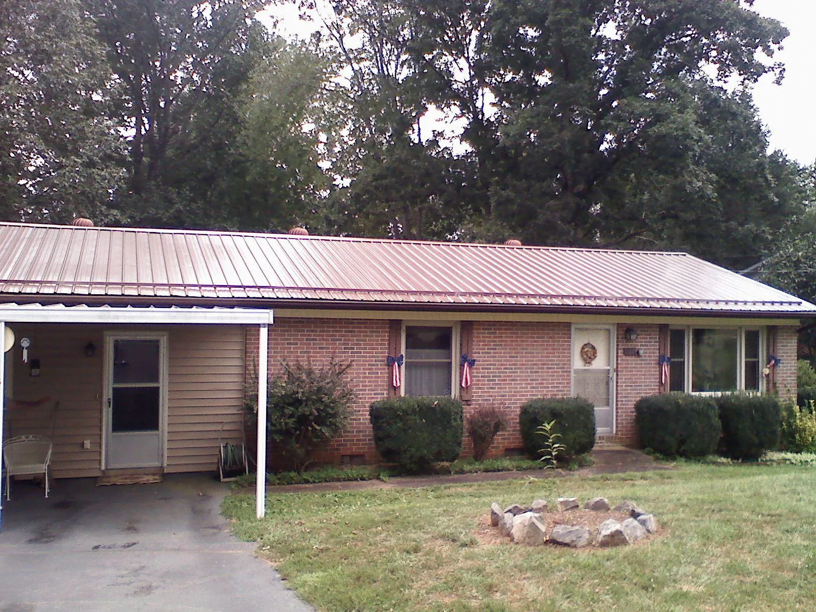 Bronze metal roof and carport on a brick ranch home — Roof Repair work by our crew in East Marion